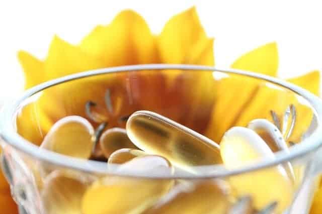 pastillas en un vaso, flor amarilla en el fondo