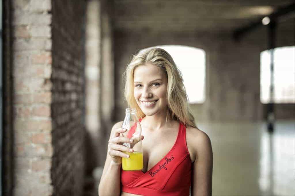 la mujer está bebiendo una bebida cítrica