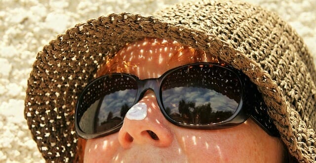  un rostro de mujer con gafas de sol y sombrero