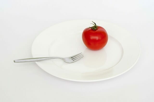 Un tomate y un tenedor en el plato