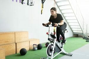  una mujer se entrena en una bicicleta estática
