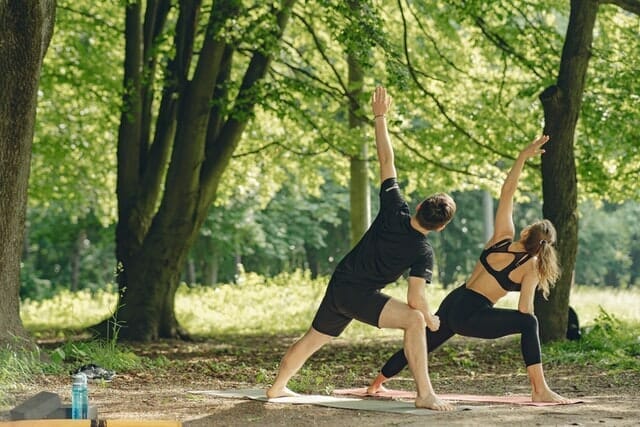  una pareja realiza ejercicios de estiramiento al aire libre
