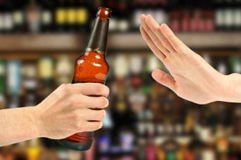  La mano sostiene la botella de alcohol